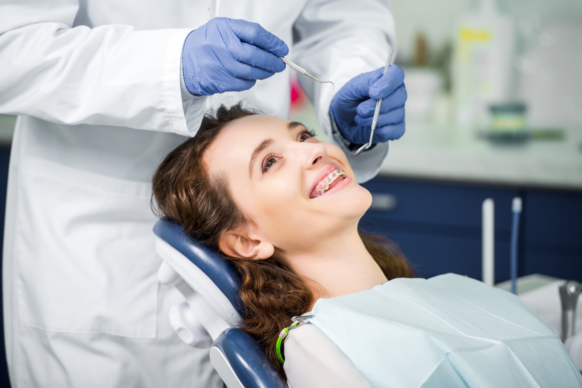 cropped-view-of-dentist-in-latex-gloves-examining-cheerful-woman-in-braces.jpg